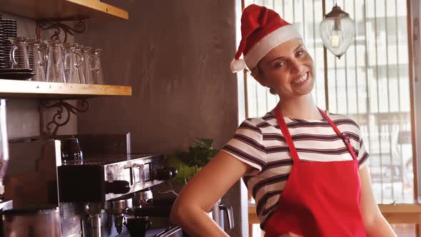 Waitress in santa hat standing with hand on hip