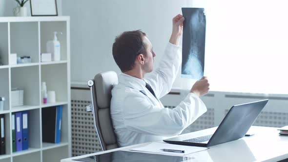 Professional medical doctor working in hospital office using computer technology.