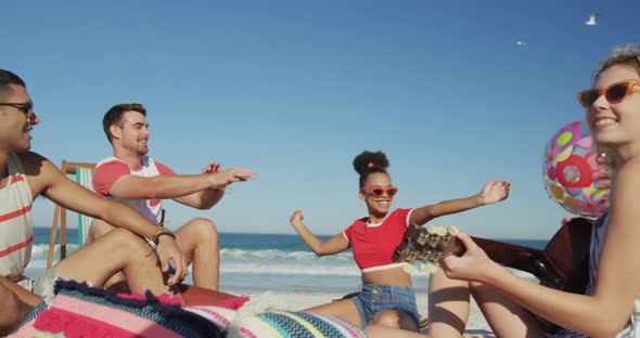 Young adult friends hanging out together at the beach 4k