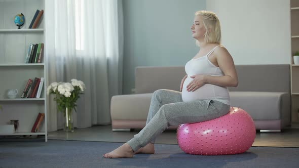 Happy Future Mother Enjoying and Rejoicing With Pregnancy, Gently Stroking Tummy