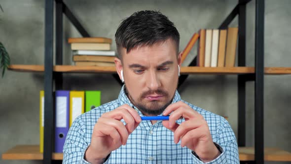 Thoughtful businessman wear wireless earphones in office thinks solution problem