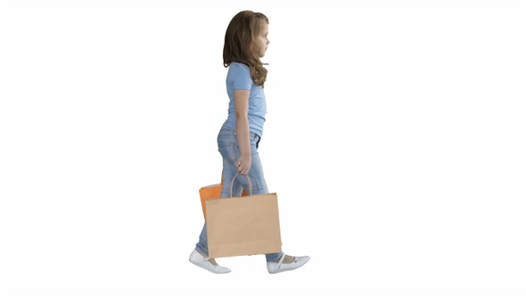 Cheerful school girl walking with shopping bags on white