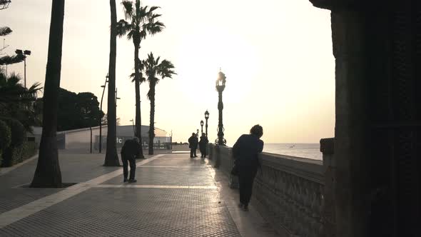 People on a promenade at sunset