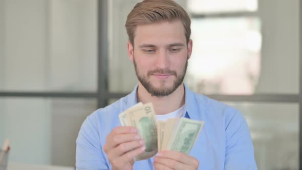 Portrait of Young Creative Man Counting Dollars