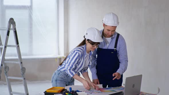 Professional Designers in Protective Helmets with Color Palette in Their Hands Choosing Renovation