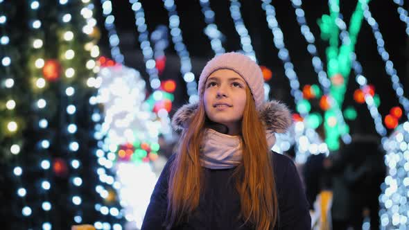 Young Girl Looking Up at Christmas Lights