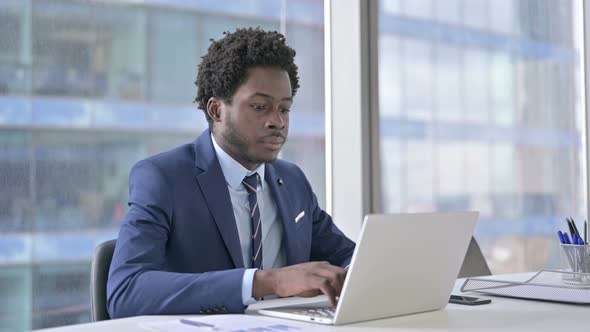 Ambitious African American Businessman Using Laptop in Office