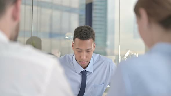 Rear Back View of Couple Having Serious Talk with Businessman on Office Desk