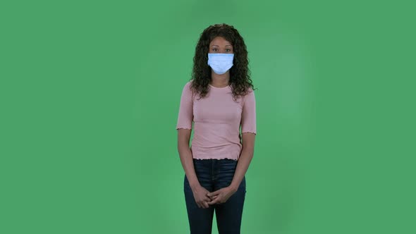 Portrait of Beautiful African American Young Woman in Medical Mask Is Looking Straight and Shaking