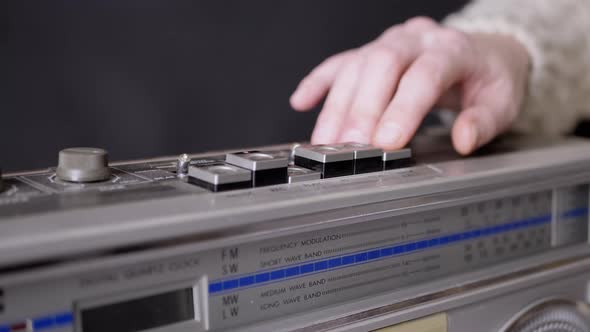 Female Fingers Pressing Buttons on an Old Vintage Tape Recorder in Dark Room