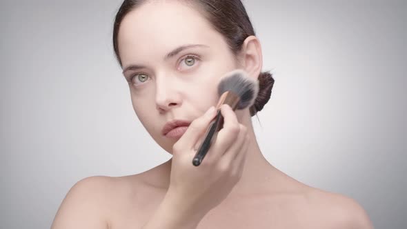Woman Doing Makeup in Front of the Mirror