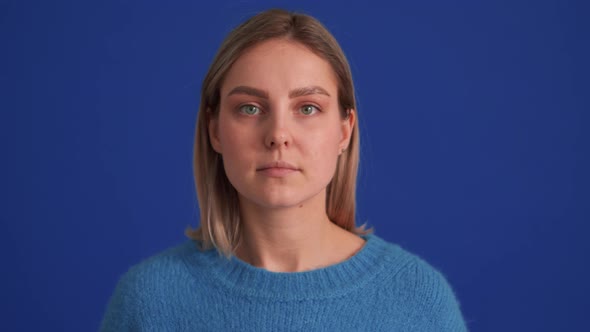 Handsome positive woman wearing blue sweater looking at the camera