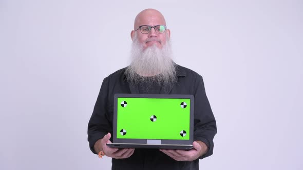 Upset Mature Bald Bearded Man Thinking While Showing Laptop