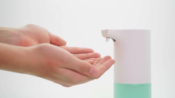 Close-up of Hands Disinfected with a Foam Automatic Dispenser, Isolated Background. Protection From