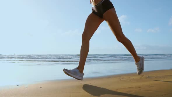 Leg Sporty Woman in White Sneakers Running Along Beautiful Sandy Beach