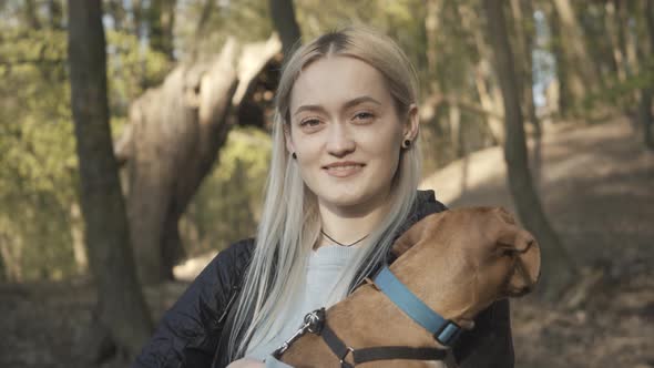 Close-up of Charming Blond Caucasian Woman with Pet Smiling at Camera. Portrait of Young Attractive