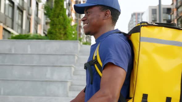 Afroamerican Man Courier Delivery with Backpack Rides Street Electric Scooter