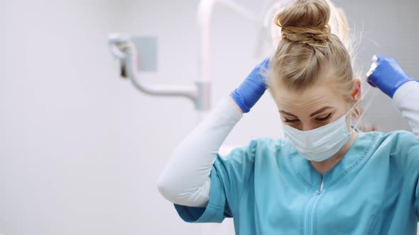 Dentist Putting on Protective Mask Before Surgery