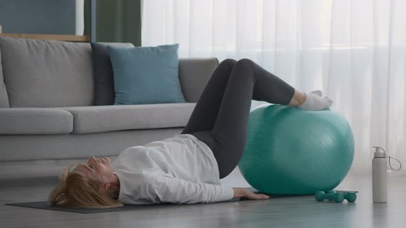 Senior Female Doing Pilates Exercising With Fitball At Home