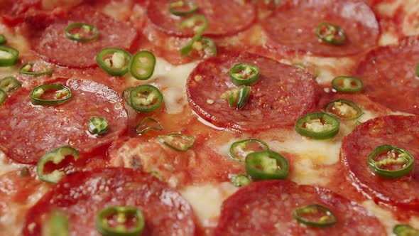 Close Up Hot Green Pepper Falls on the Pizza Ready Prepared with Pepperoni
