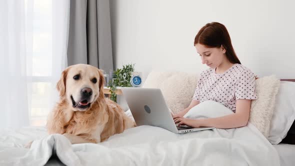 Girl with Laptop and Golden Retriever Dog