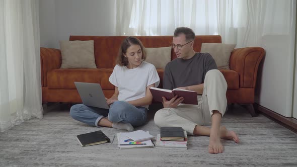 Male and Female Student to Study at Home with Books Notebooks and a Laptop While Sitting on the