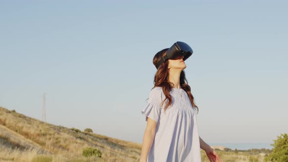 Girl with Virtual Reality Glasses Looks at the Futuristic Nature