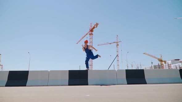 Happy Caucasian Man Builder in Hard Hat Dancing. Worker Funny Moves Background Construction Site