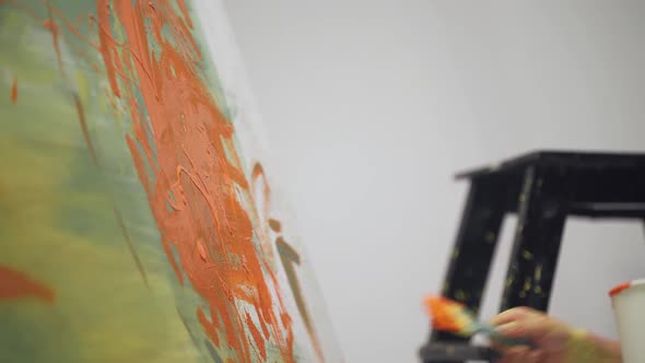 Kid Boy Draws with a Brush on a Large Canvas in a White Room Child Artist Draws a Color Abstraction