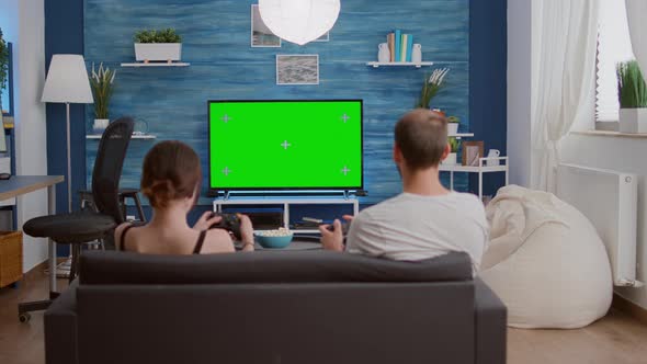 Couple of Gamers Spending Free Time Playing Fast Paced Console Action Game on Green Screen