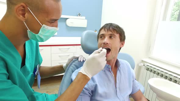 Smiling male patient giving thumbs up after routine dental check up