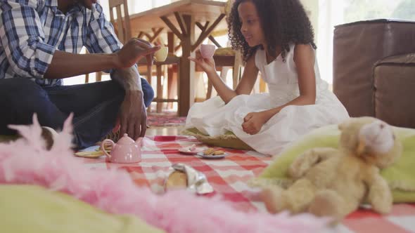 African american father and daughter having picnic at home