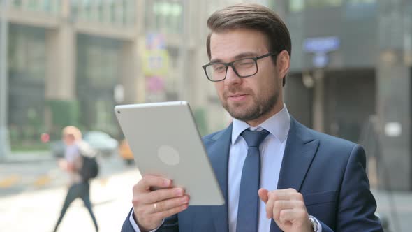 Businessman Talking on Video Call on Tablet in Street