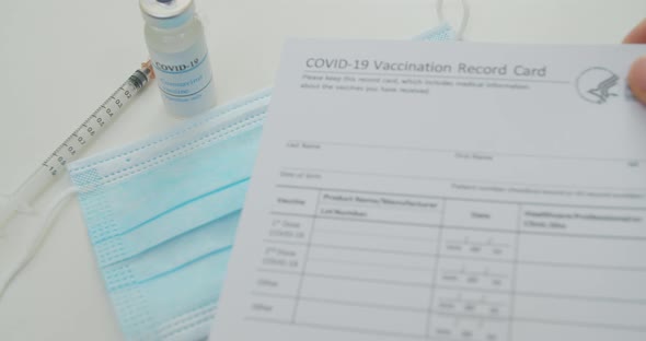 Medical Mask and COVID19 Vaccine Doctor Hand Put Vaccination Record Card Approved By CDC with Corona