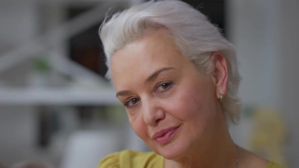 Headshot of Gorgeous Confident Senior Woman with Grey Hair and Brown Eyes Looking at Camera