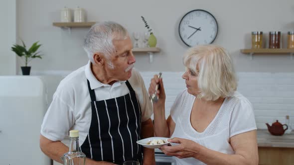 Senior Woman Feeding Man with Raw Sprouts Buckwheat with Nuts. Eco Food Eating Diet. World Vegan Day