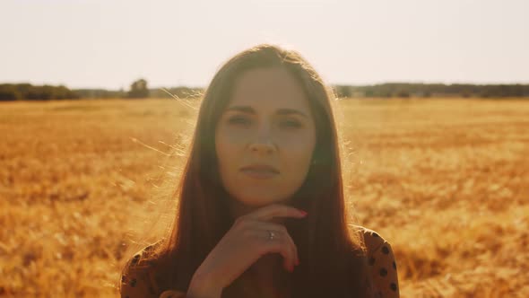 Pregnant woman in the rays of the sunset in the field