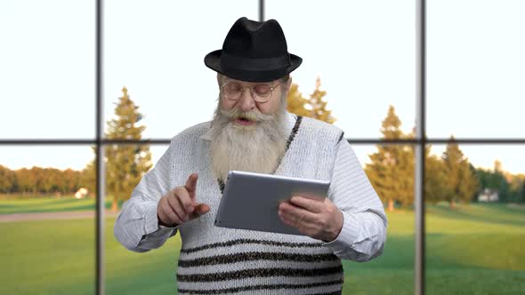 Mature Man Using App on Digital Tablet.