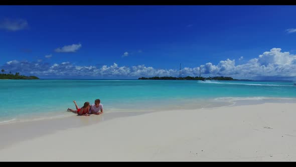 Man and woman in love on idyllic bay beach voyage by blue ocean and white sandy background of the Ma