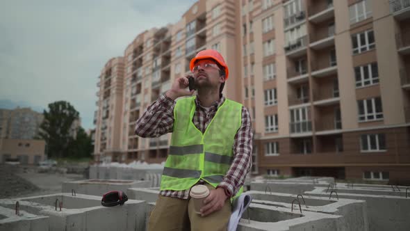 Male Builder Foreman Worker or Architect Working on Construction Building Site Drinking Tea or