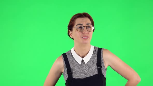 Portrait of Funny Girl in Round Glasses Is Feeling Very Bad, Her Stomach Hurting. Green Screen