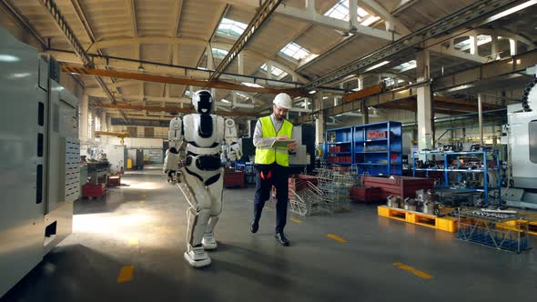 Male Technician Is Walking with a Cyborg