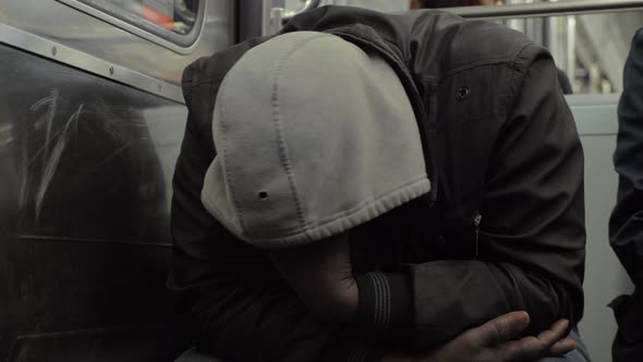 Homeless man dozing when traveling by metro train