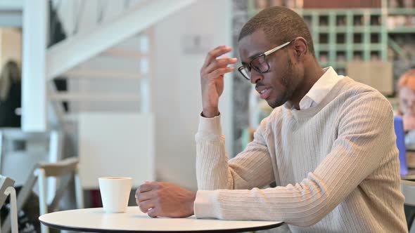 Concerned African Man Thinking in Cafe Worrying