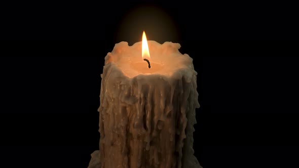 An old and melted candle rotates in front of a black background