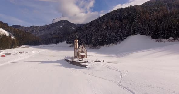 AERIAL: Church with snow in Dolomites in Italy