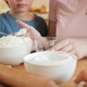 Closeup of Little Son Helping Mother Pouring Flour in Bowl for Making Biscuit or Dough - VideoHive Item for Sale