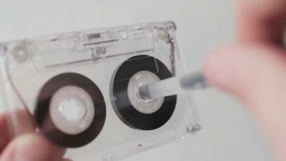 Man Manually Rewind a Cassette Tape