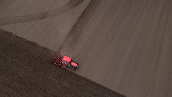 Agricultural Red Small Tractor in the Field Plowing Works in the Field