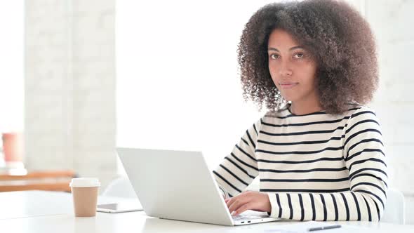 Cheerful African Woman with Laptop Smiling at Camera 